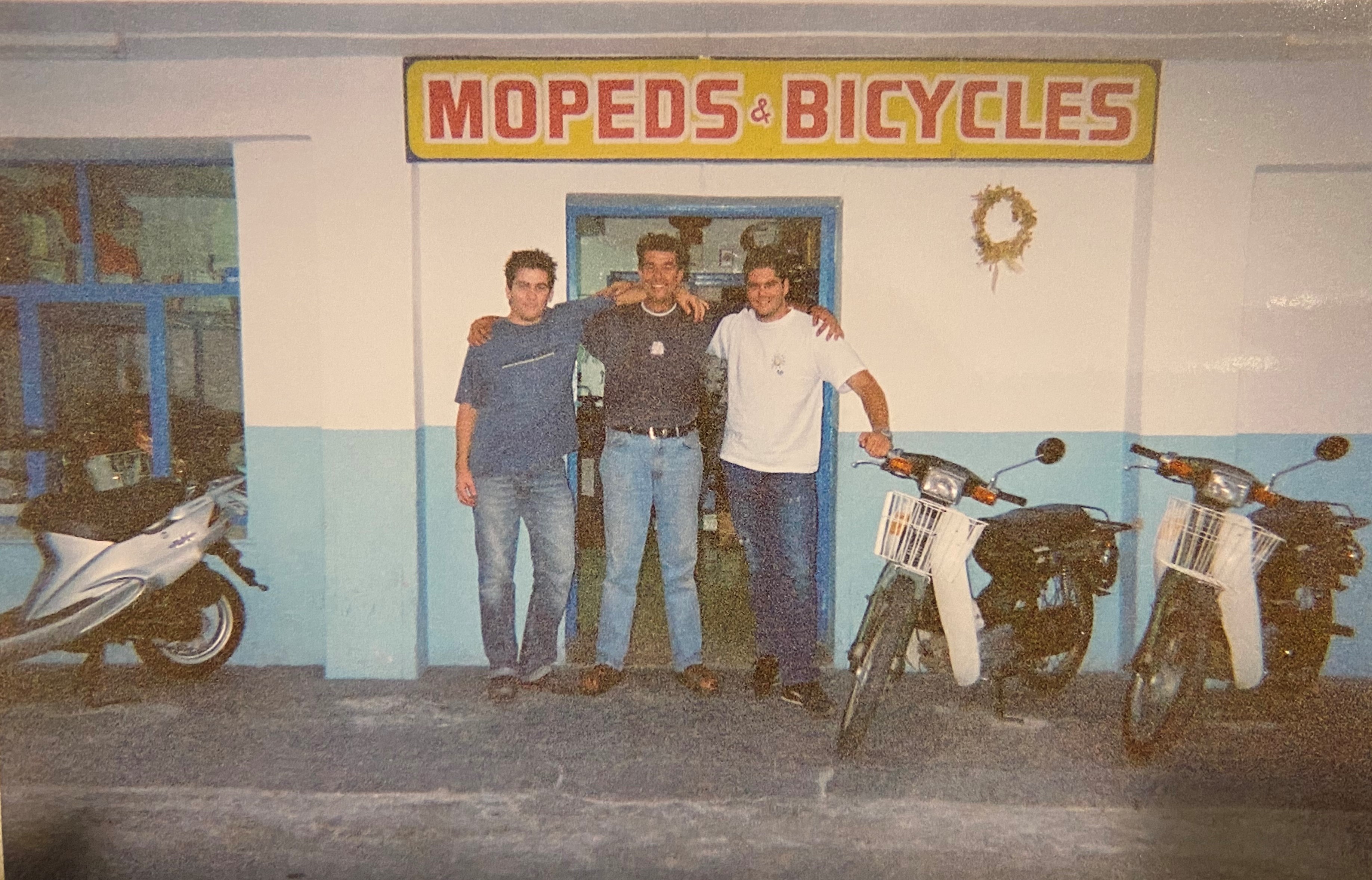 Young Panagiotis Logothetis smiling at his Rental Shop located in the heart of Megalochori